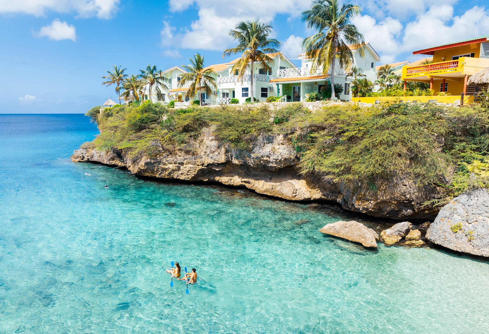 Two people kayaking in clear turquoise water near Playa Lagun